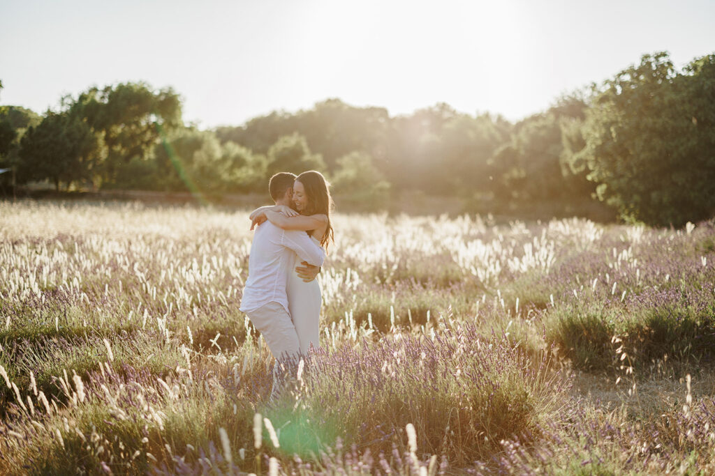 Couple walking through lavender fields in Provence during romantic sunset engagement photoshoot