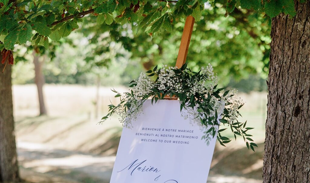 wedding welcome sign in Provence wedding venue with greenery showing welcome in French, italian, and English for multicultural wedding