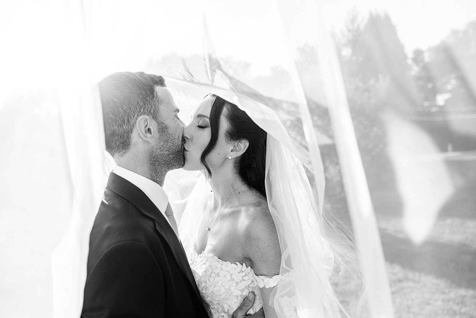 romantic couple kissing under wedding veil in provence